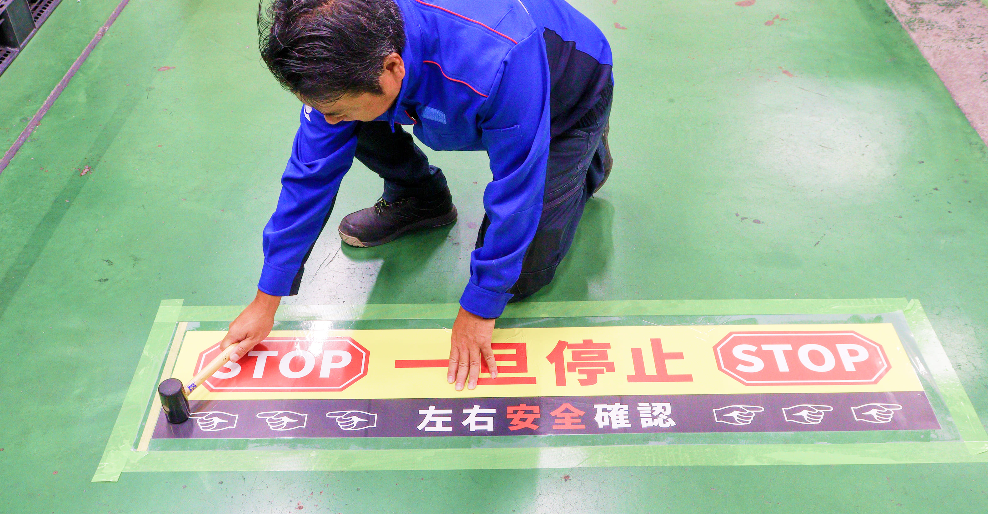 スマートマークを床に貼る男性