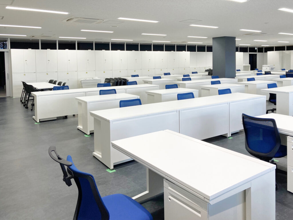 白いデスクと青と黒の椅子のオフィス